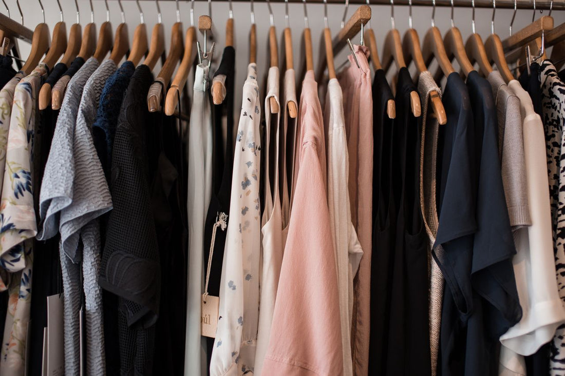 An array of clothing on wooden hangers in a local Long Island boutique