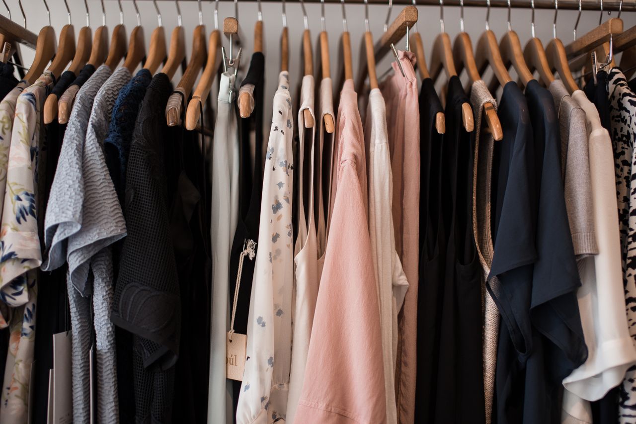 An array of clothing on wooden hangers in a local Long Island boutique