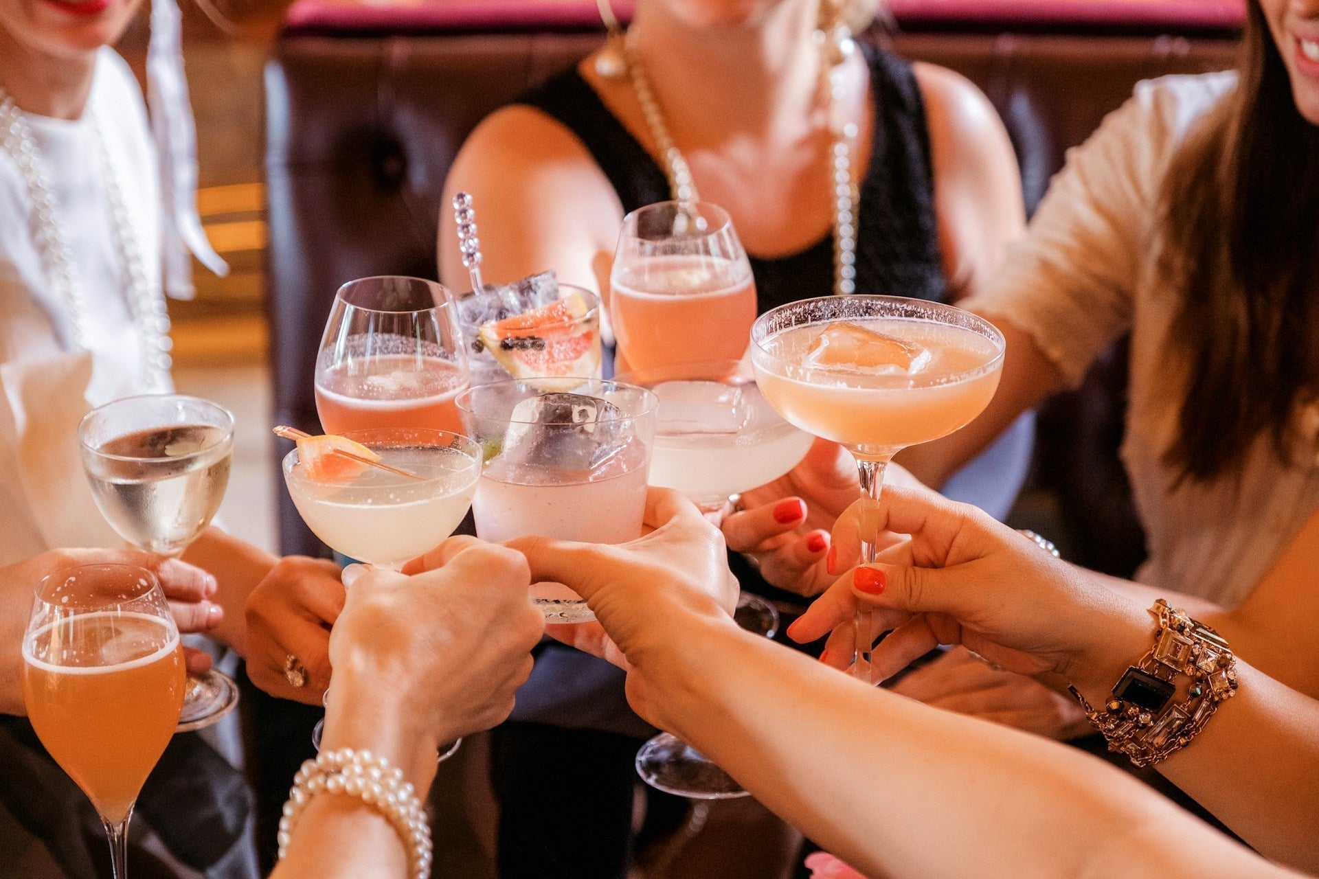 Friends toasting with colorful N/A vodka cocktails