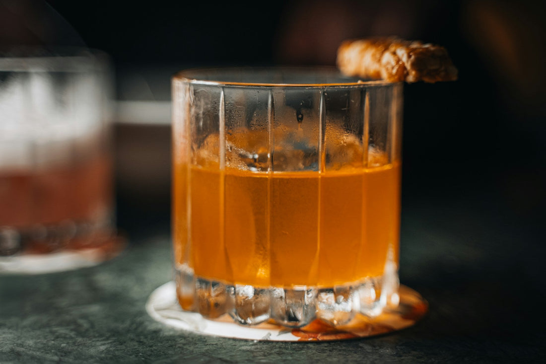 Non-alcoholic Godmother cocktail in a whiskey glass with a garnish