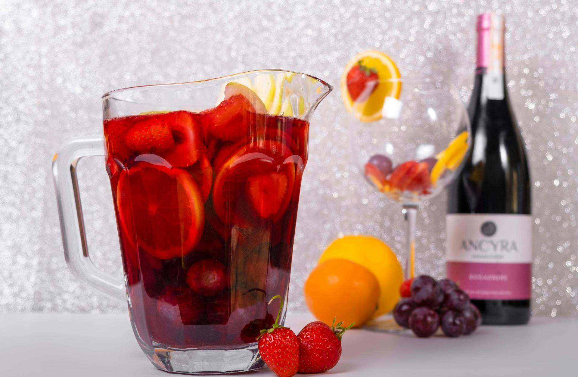A pitcher of sangria surrounded by fresh fruit